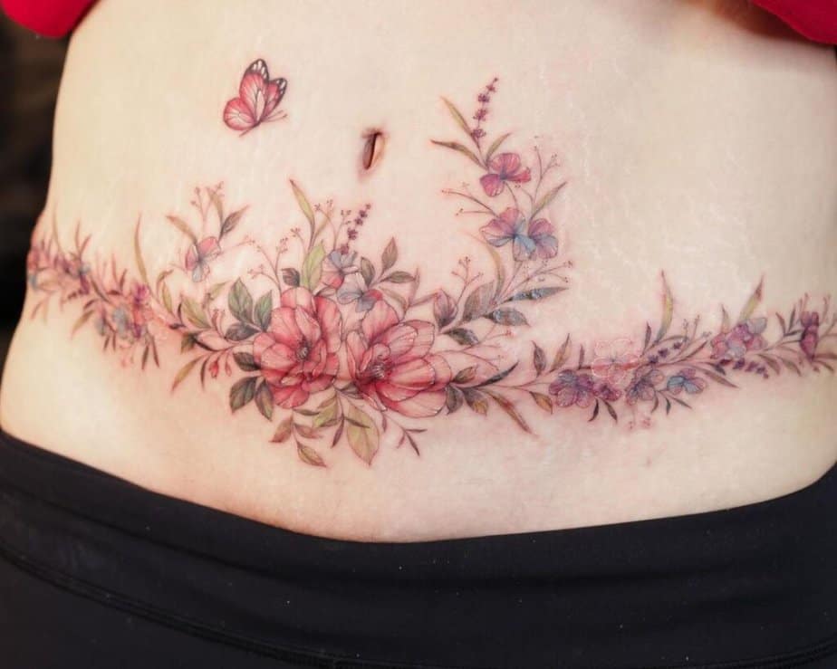 3. Ein buntes Bauchdecken-Tattoo mit Blumen und Schmetterlingen