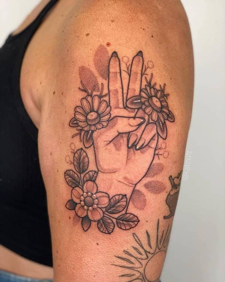 Ein Friedenszeichen-Tattoo: die Hand hochhalten