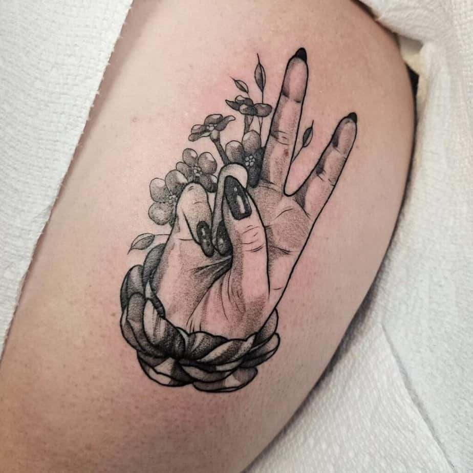 Ein Friedenszeichen-Tattoo: die Hand hochhalten