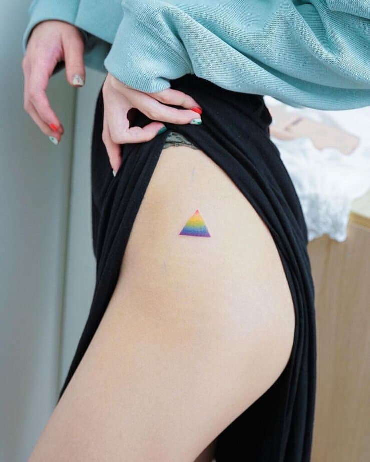 16. Ein Regenbogen-Dreieck-Tattoo auf der Hüfte