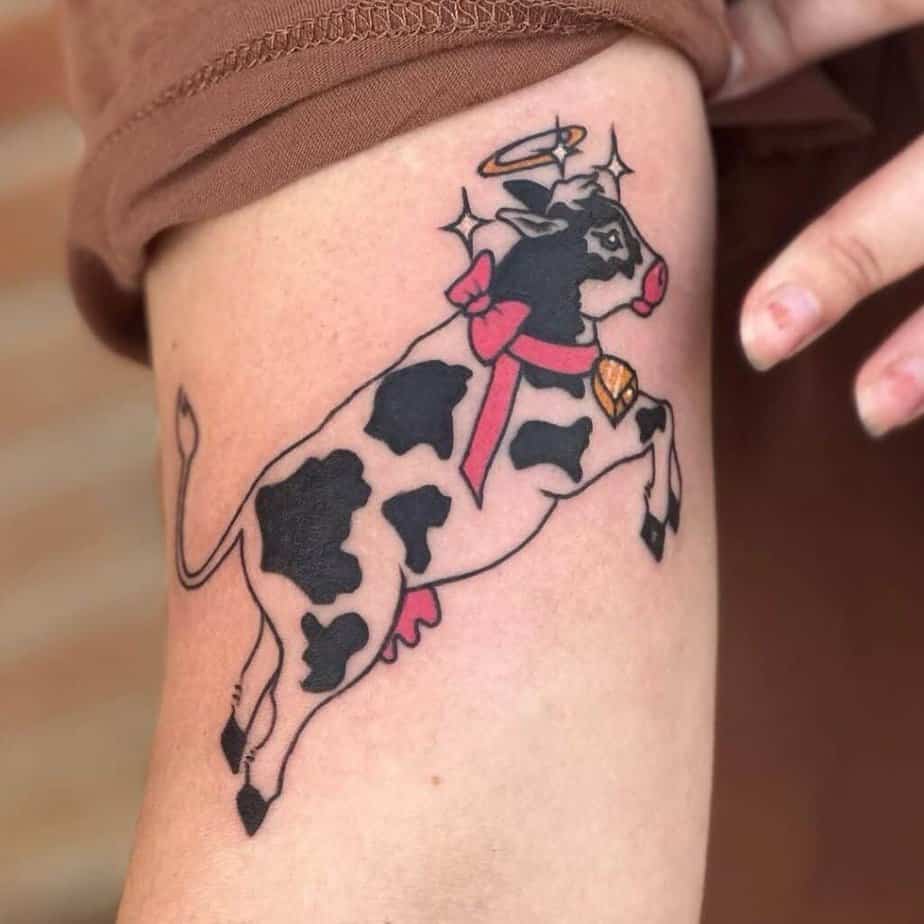 4. Eine Tätowierung einer Kuh mit einer rosa Schleife