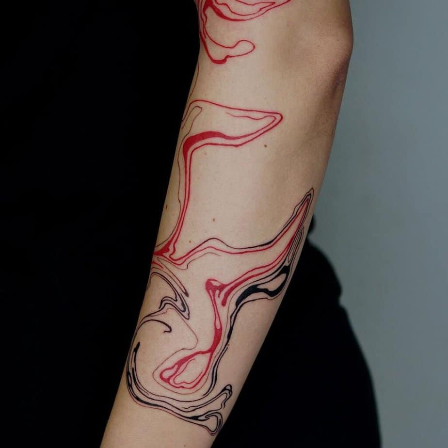 3. Eine abstrakte Tätowierung in Schwarz und Rot auf dem Unterarm