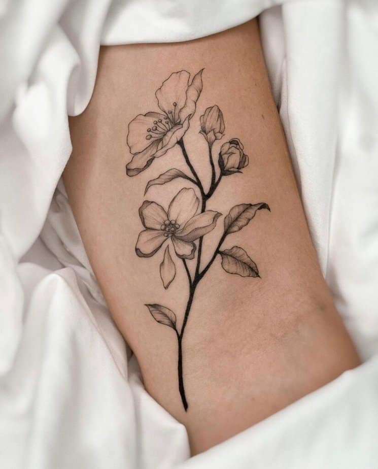 4. Ein Apfelbaumzweig-Tattoo auf dem Arm
