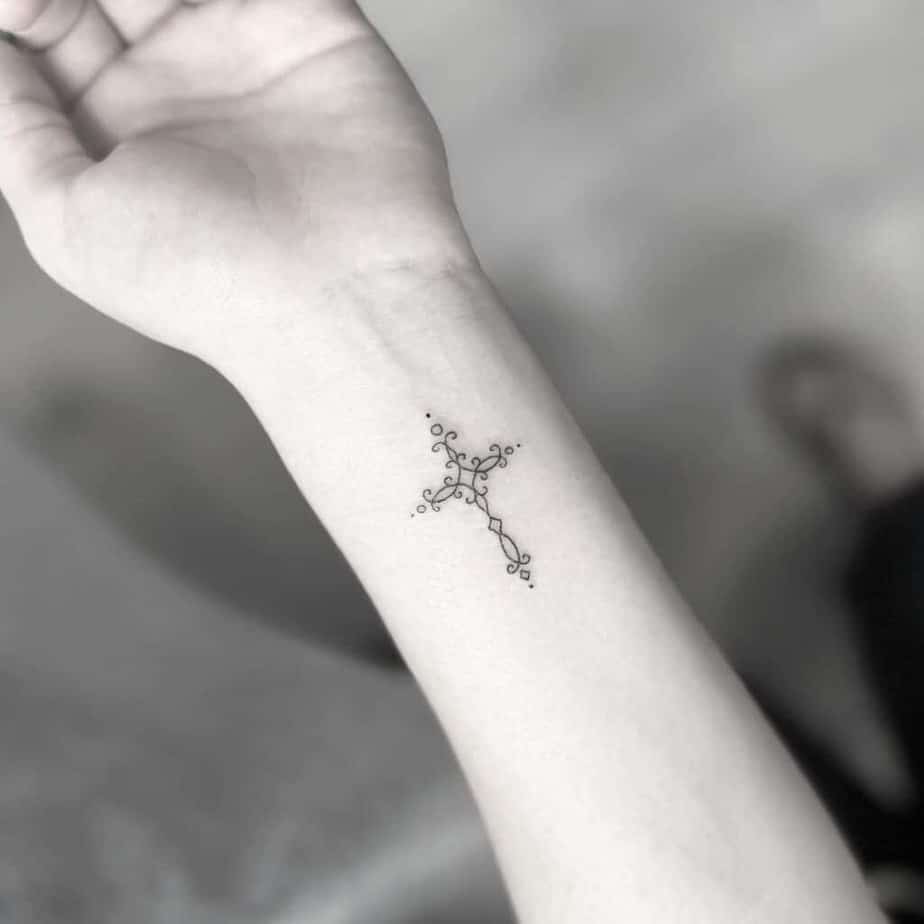 16. Ein minimalistisches Kreuz-Tattoo mit Ranken