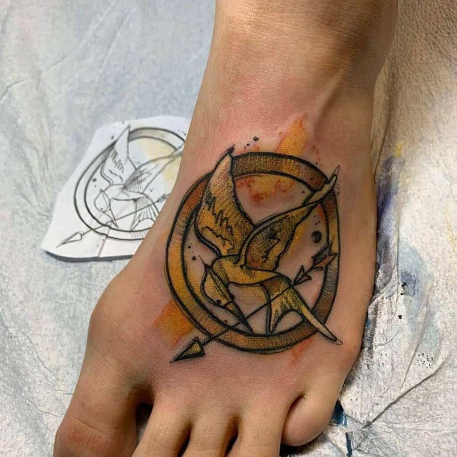 20. Ein Mockingjay-Symbol-Tattoo auf dem Fuß 