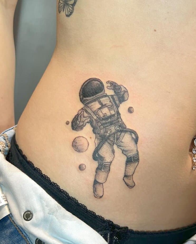 Astronautentattoos, die auf dem Bauch sitzen