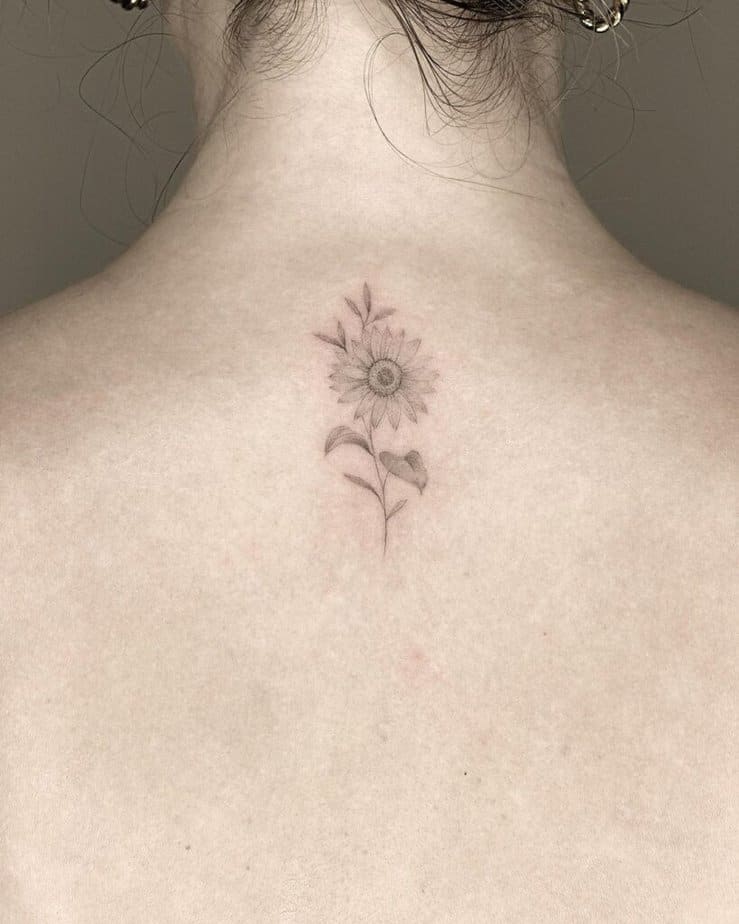 11. Eine zarte Sonnenblumen-Tätowierung auf dem Rücken 