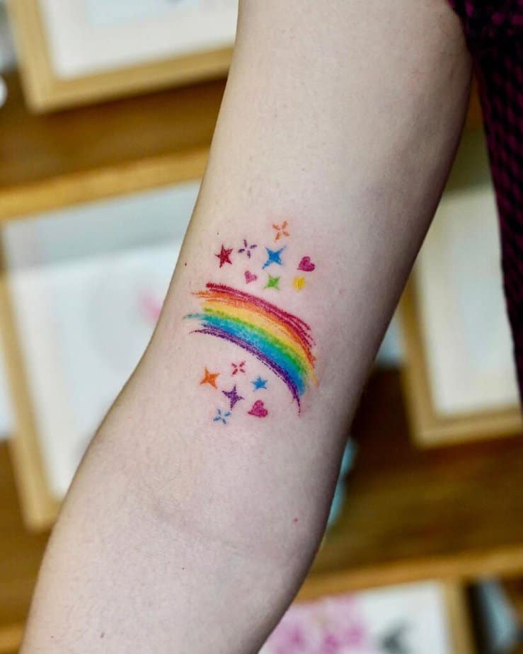 10. Ein Buntstift-Tattoo mit einem Regenbogen, Sternen und Herzen