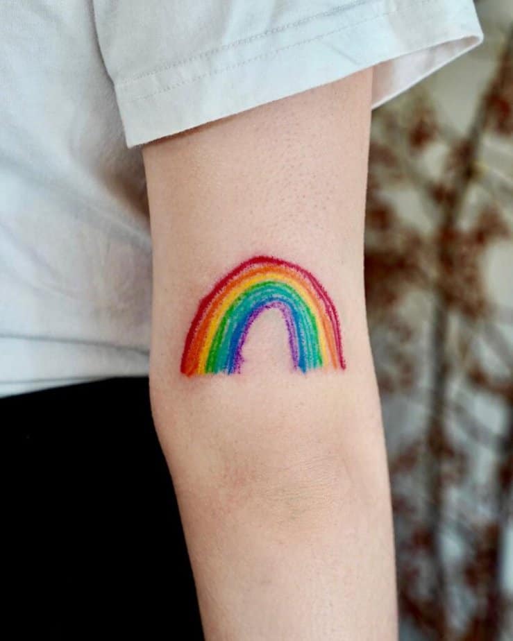 7. Eine Tätowierung mit Buntstiften eines Regenbogens auf der Rückseite des Arms