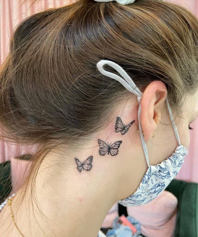 6. Eine Tätowierung mit drei Schmetterlingen hinter dem Ohr