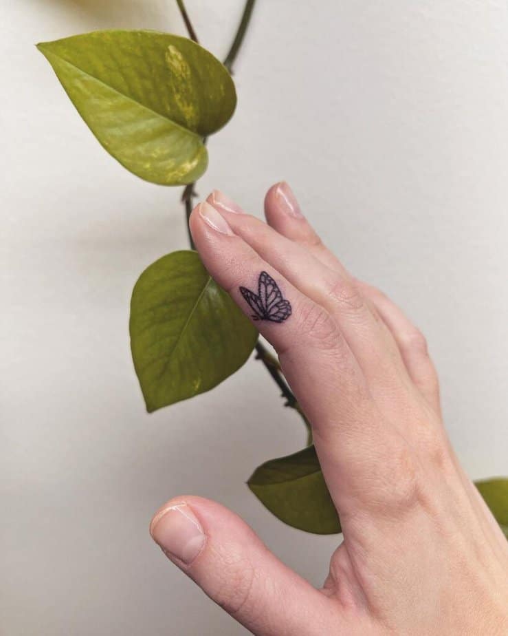 16. Ein handgestochenes Schmetterlings-Fingertattoo 