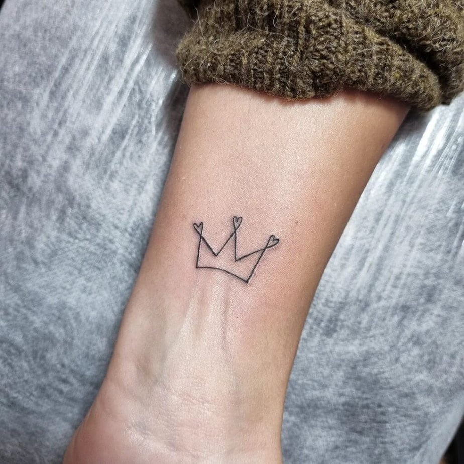 23. Ein Kronen-Tattoo mit Linien auf dem Handgelenk