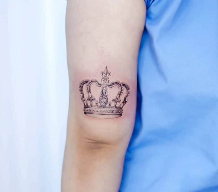 6. Ein zartes Kronen-Tattoo auf der Rückseite des Arms