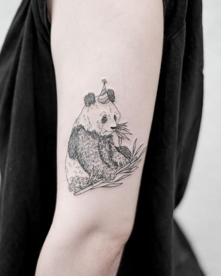 22. Eine Tätowierung eines Pandas, der an Bambusblättern kaut 