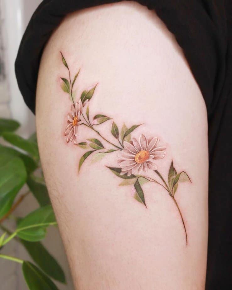 19. Ein Gänseblümchen-Tattoo auf dem Oberarm