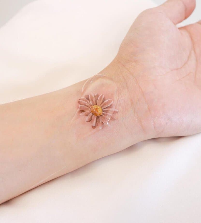 20. Ein Gänseblümchen-Tattoo auf dem Handgelenk