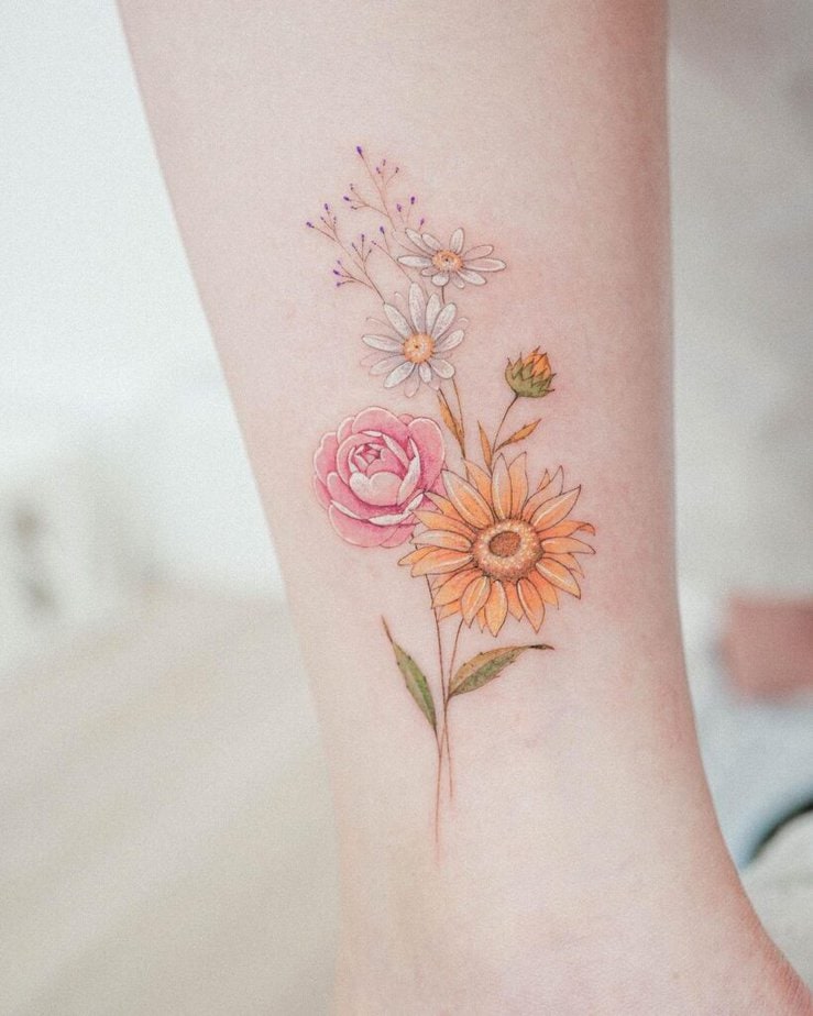 21. Ein Gänseblümchen, eine Sonnenblume und eine Kamelie als Tattoo 