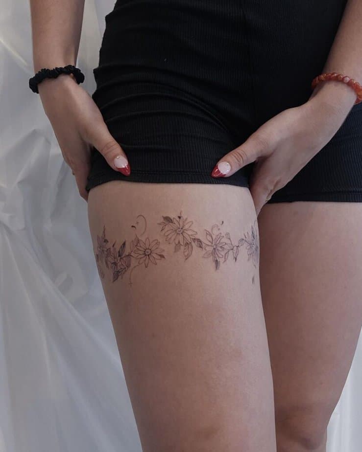 23. Ein Gänseblümchen-Tattoo um den Oberschenkel 
