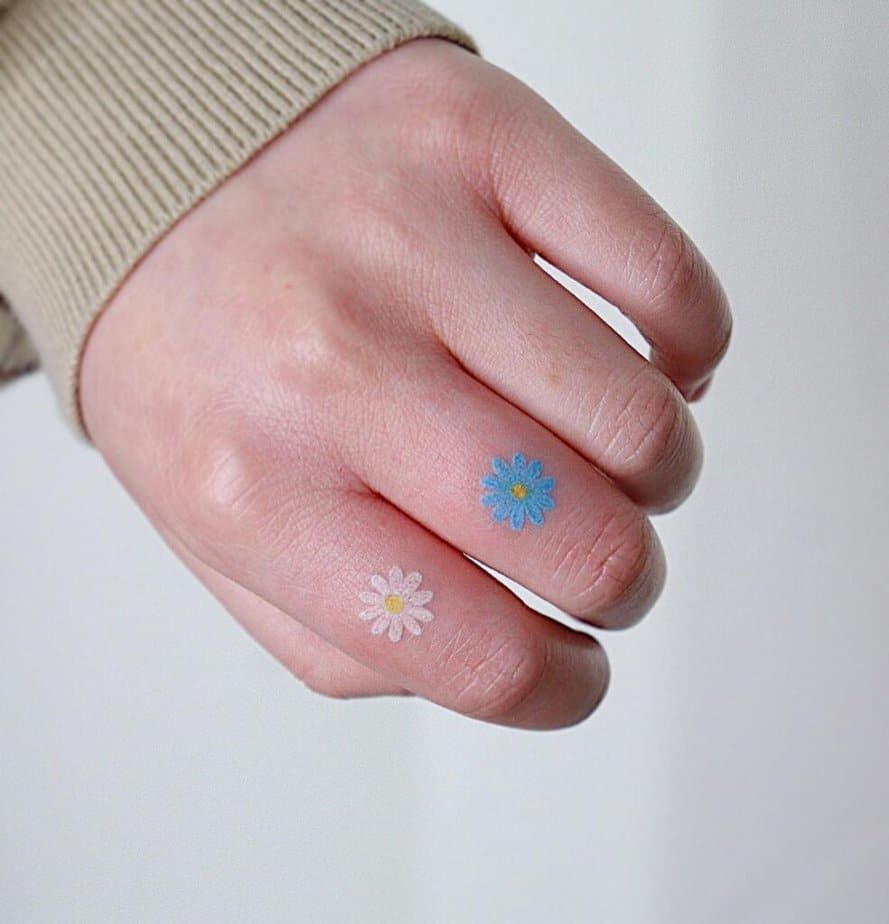 9. Ein blau-weißes Gänseblümchen-Fingertattoo 