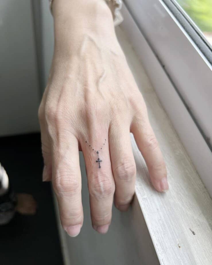 Ein stilvolles Kreuz-Tattoo auf deinem Finger 