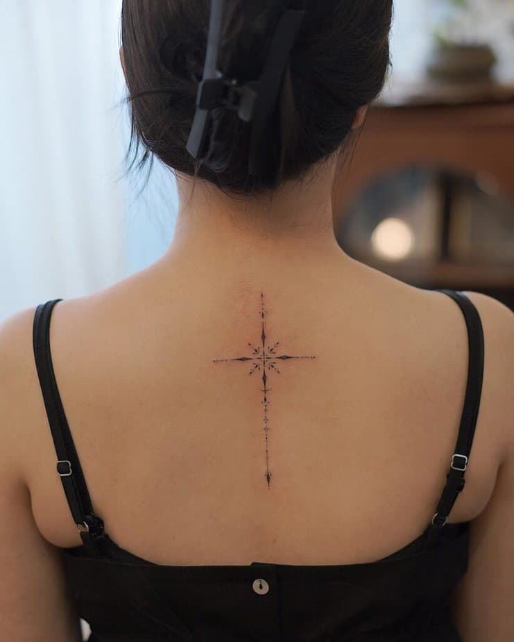 Ein feminines Kreuz-Tattoo auf dem Rücken 