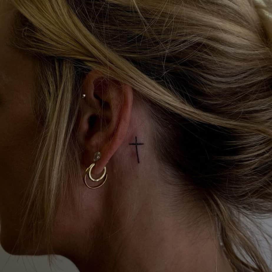 Ein süßes Kreuz-Tattoo am Ohr 