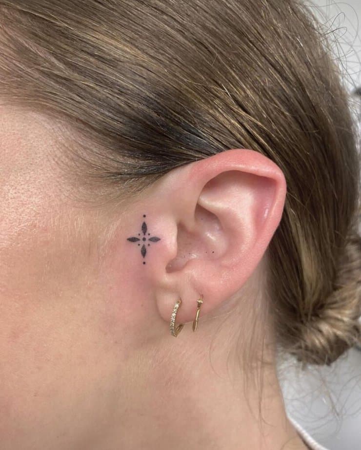 Ein süßes Kreuz-Tattoo am Ohr 