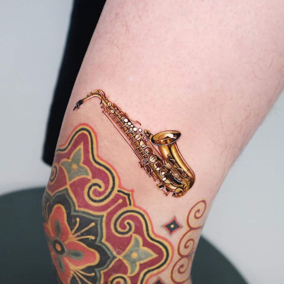 20. Ein farbiges Saxophon-Tattoo oberhalb des Knies 