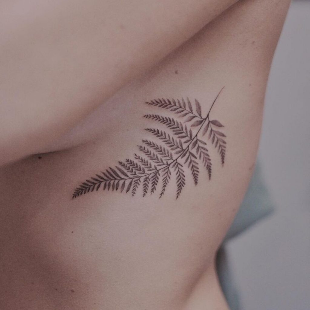 Ein Farn-Tattoo auf dem Brustkorb