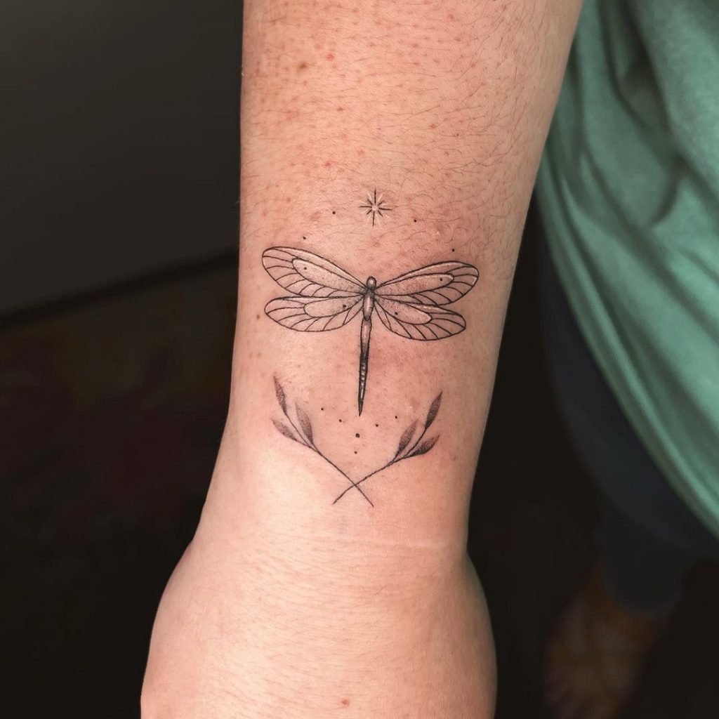 Ein Libellen-Tattoo auf dem Handgelenk
