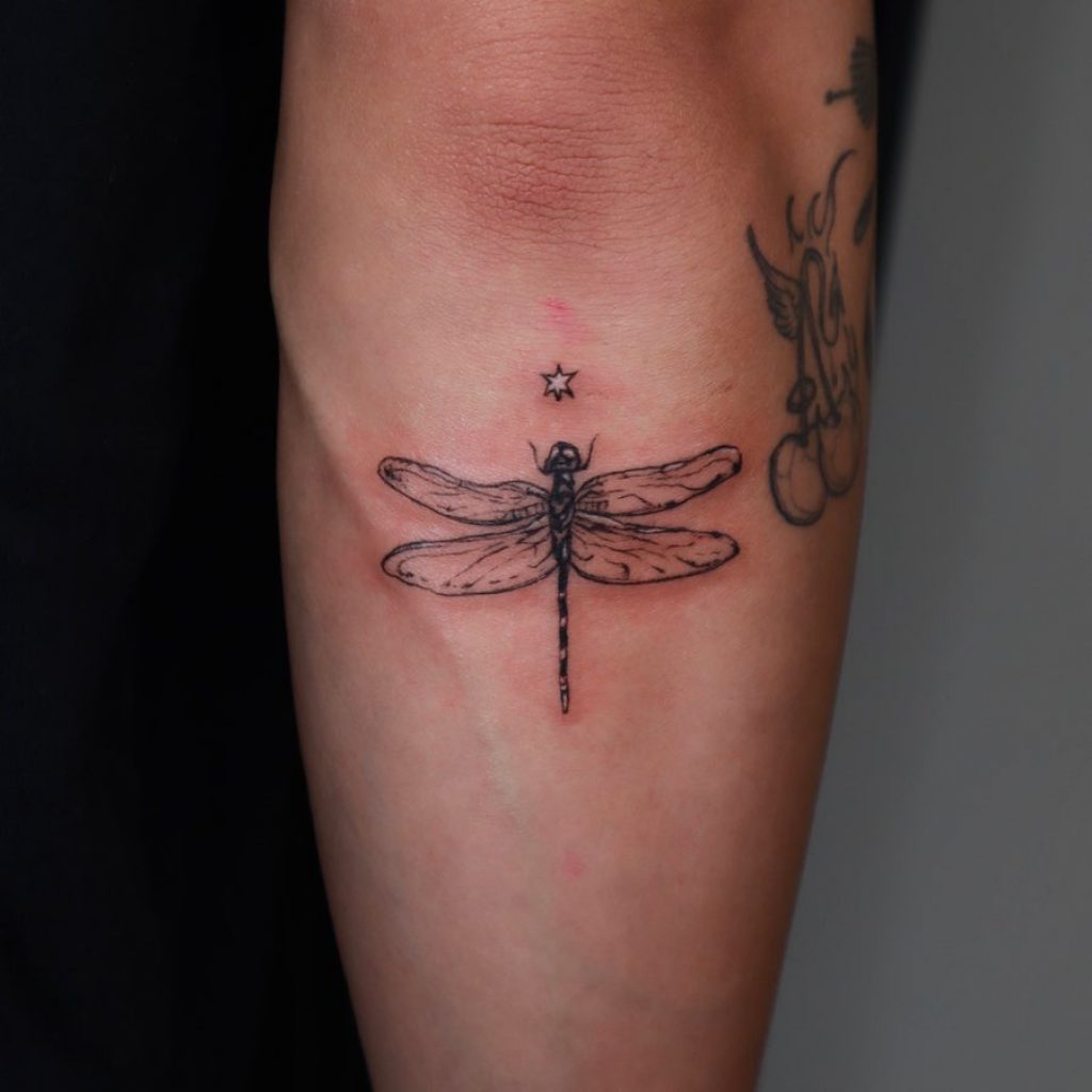 Ein Libellen-Tattoo unter dem Ellenbogen
