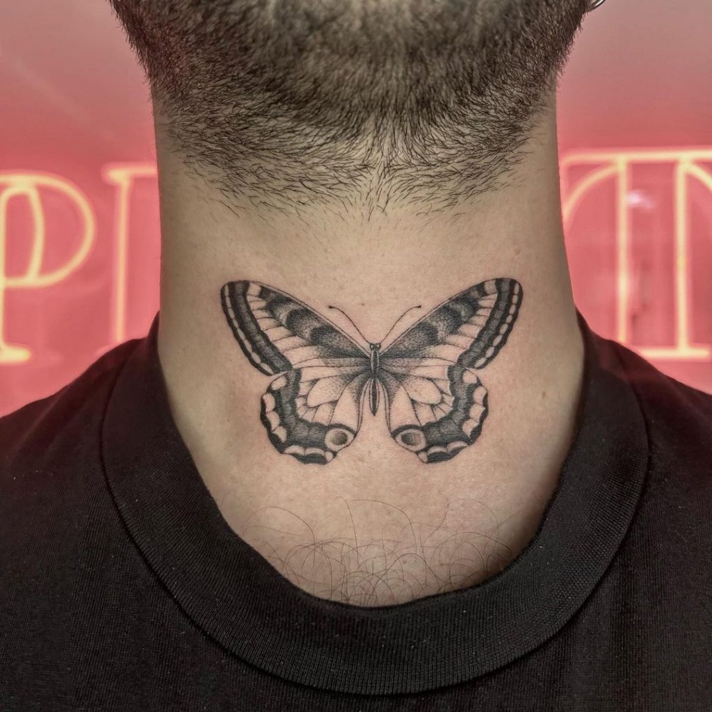 Ein Schmetterlings-Tattoo auf der Vorderseite des Halses