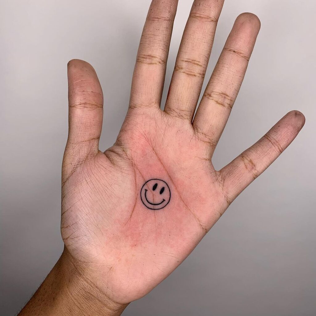Ein Smiley-Tattoo auf der Handfläche