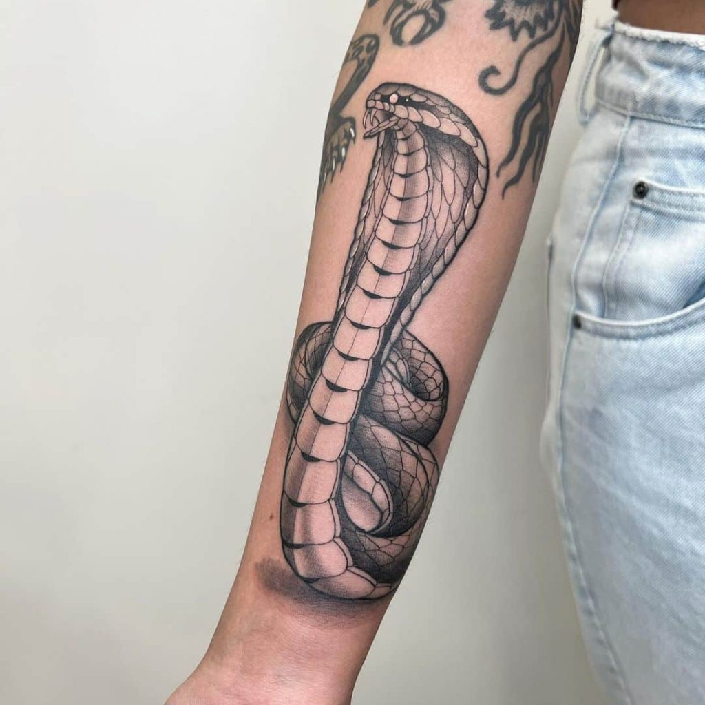 Eine Kobra-Tätowierung auf dem Arm
