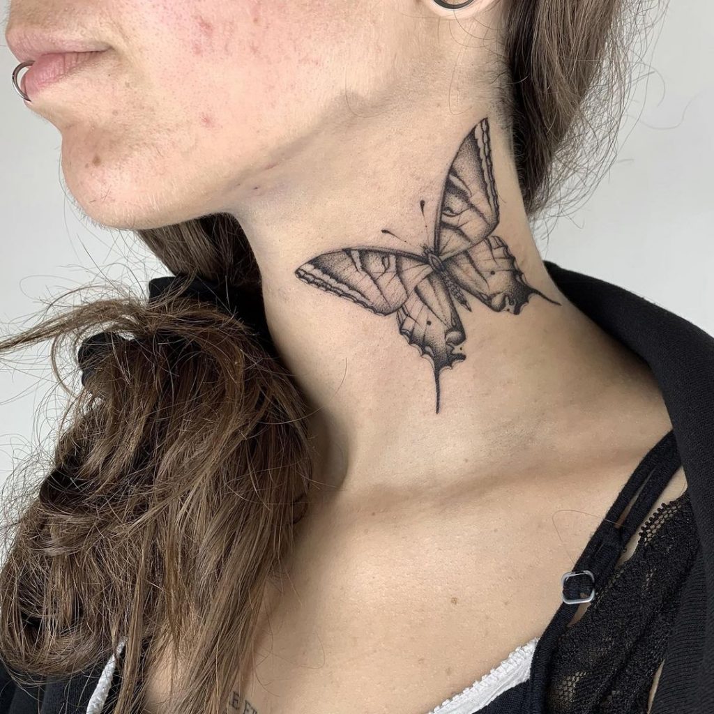 Eine Schmetterlings-Tätowierung an der Seite des Halses