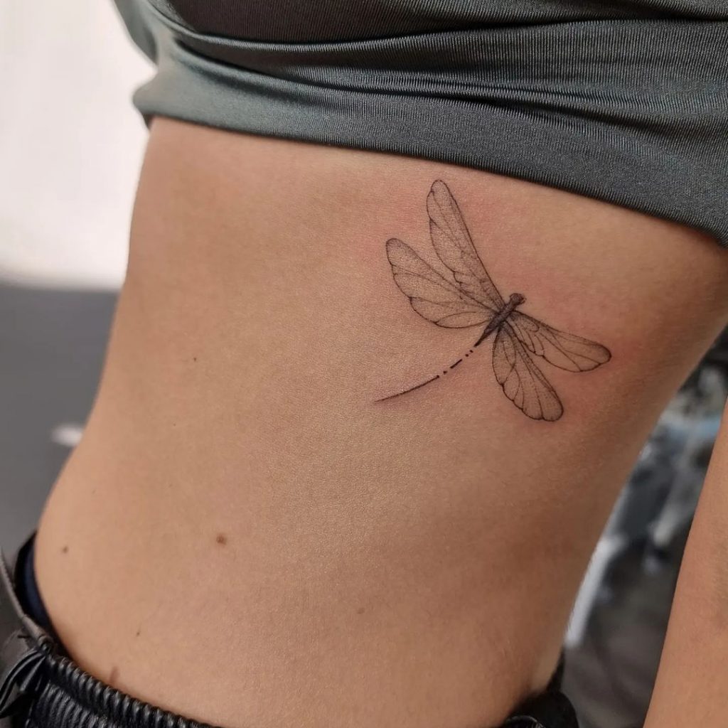 Eine Tätowierung mit einer Libelle auf dem Brustkorb