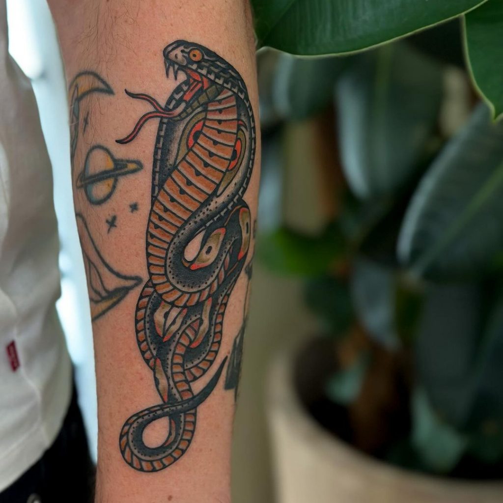 Eine traditionelle Kobra-Tätowierung auf dem Unterarm