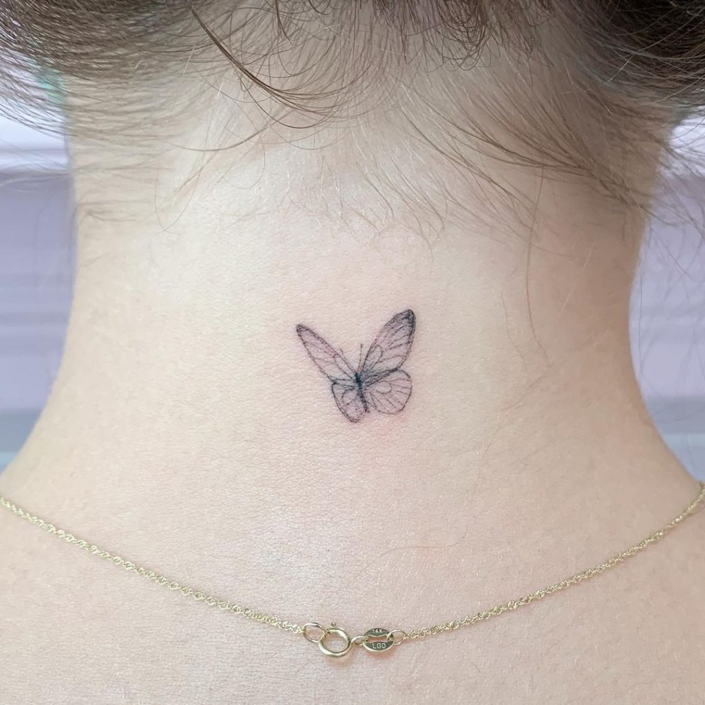 Eine winzige Schmetterlings-Tätowierung auf der Rückseite des Halses