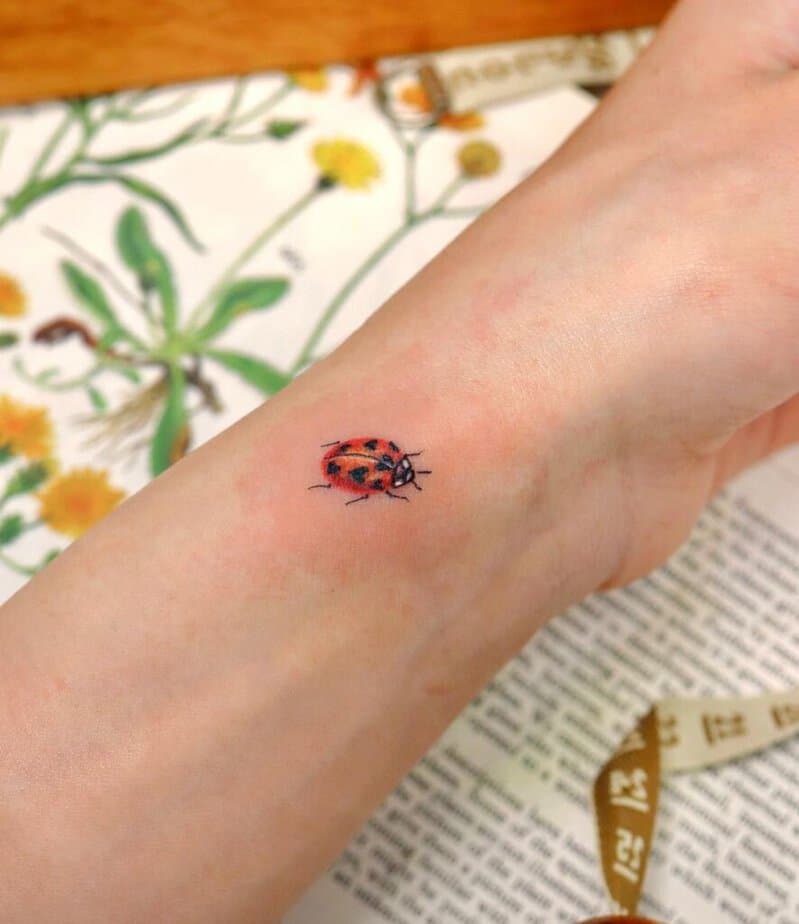 16. Ein Marienkäfer-Tattoo am Handgelenk