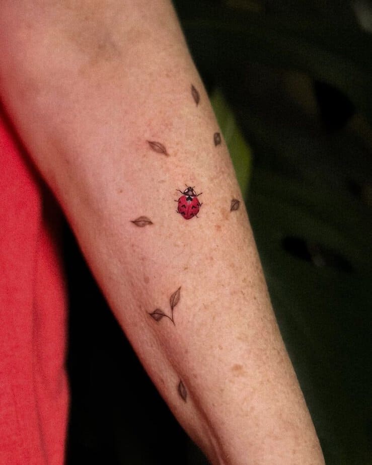 19. Eine Tätowierung eines Marienkäfers mit Blättern 