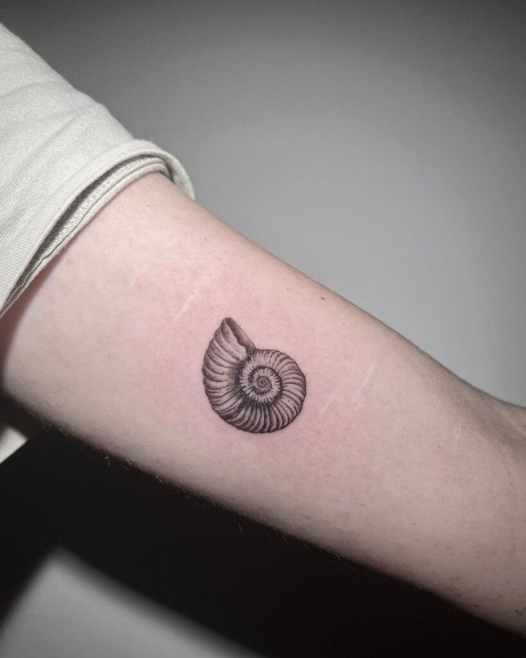 8. Ein Ammonitenmuschel-Tattoo auf dem Bizeps