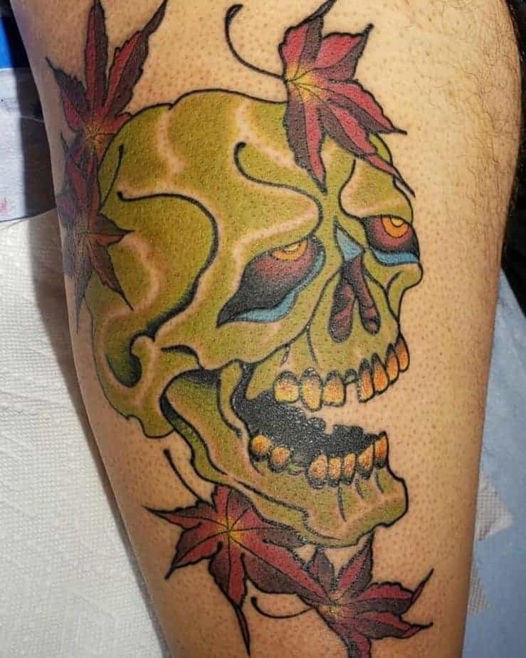 14. Grüner Totenkopf und rote Blätter Oberschenkel-Tattoo für Männer