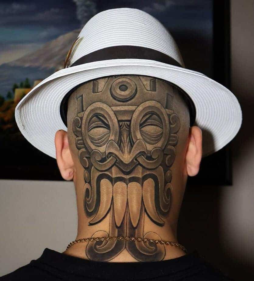 19. Aztekenmasken-Tattoo auf dem Hinterkopf