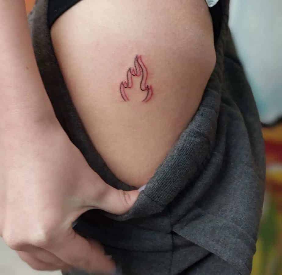 8. Ein Feuer-Tattoo mit schwarzer und roter Tinte auf der Hüfte