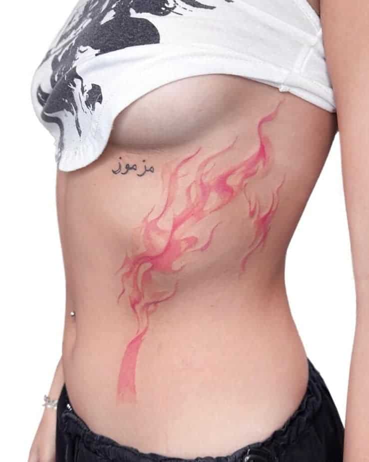 16. Ein Feuer-Tattoo auf der Seite des Bauches
