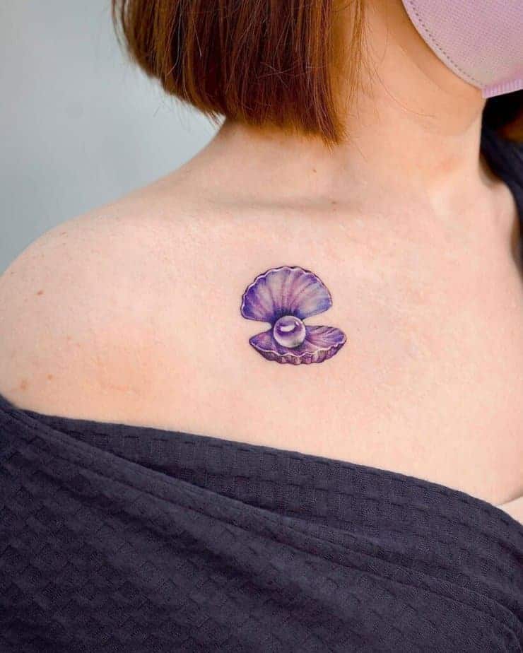 6. Ein lila Muschel-Perlen-Tattoo auf dem Schlüsselbein