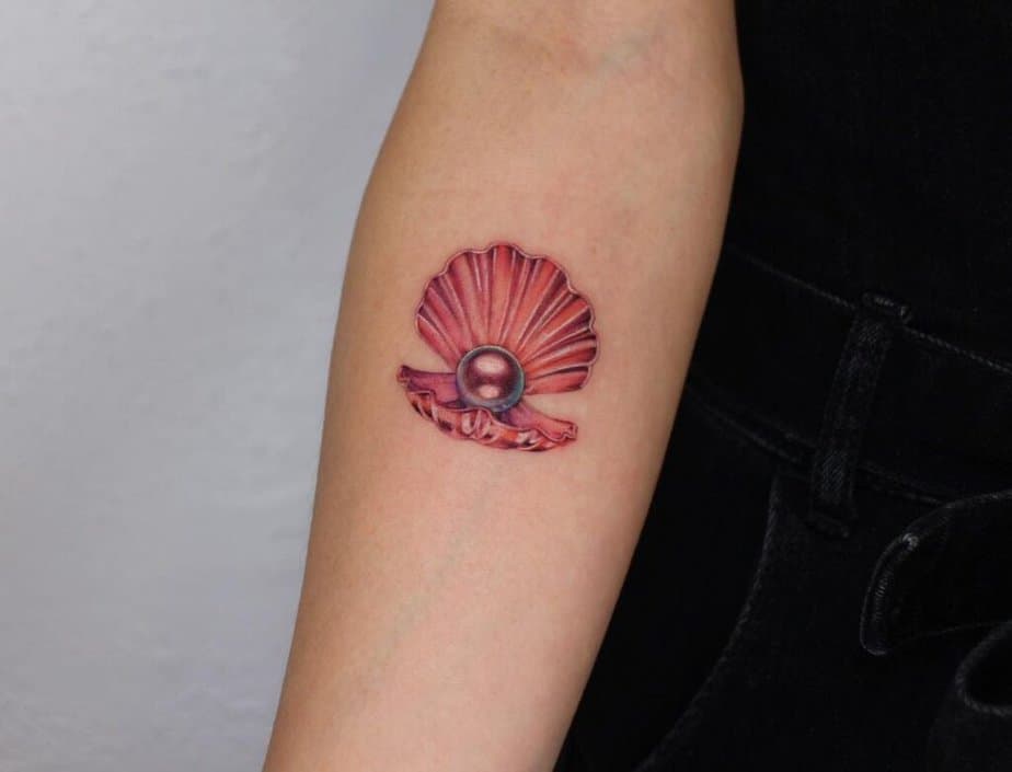8. Ein rotes Muschel-Perlen-Tattoo auf dem Unterarm