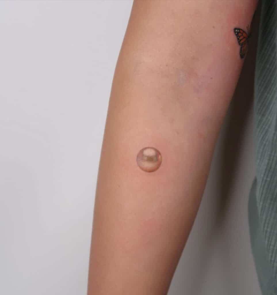 11. Ein realistisches Perlen-Tattoo auf dem Unterarm