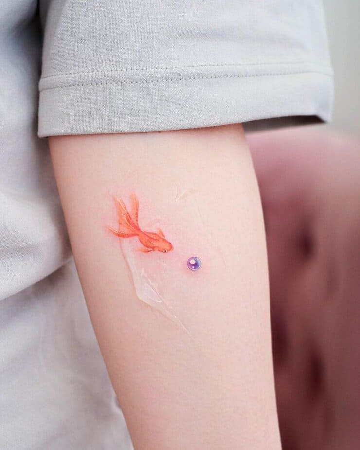 13. Ein lila Perlen-Tattoo mit einem Goldfisch
