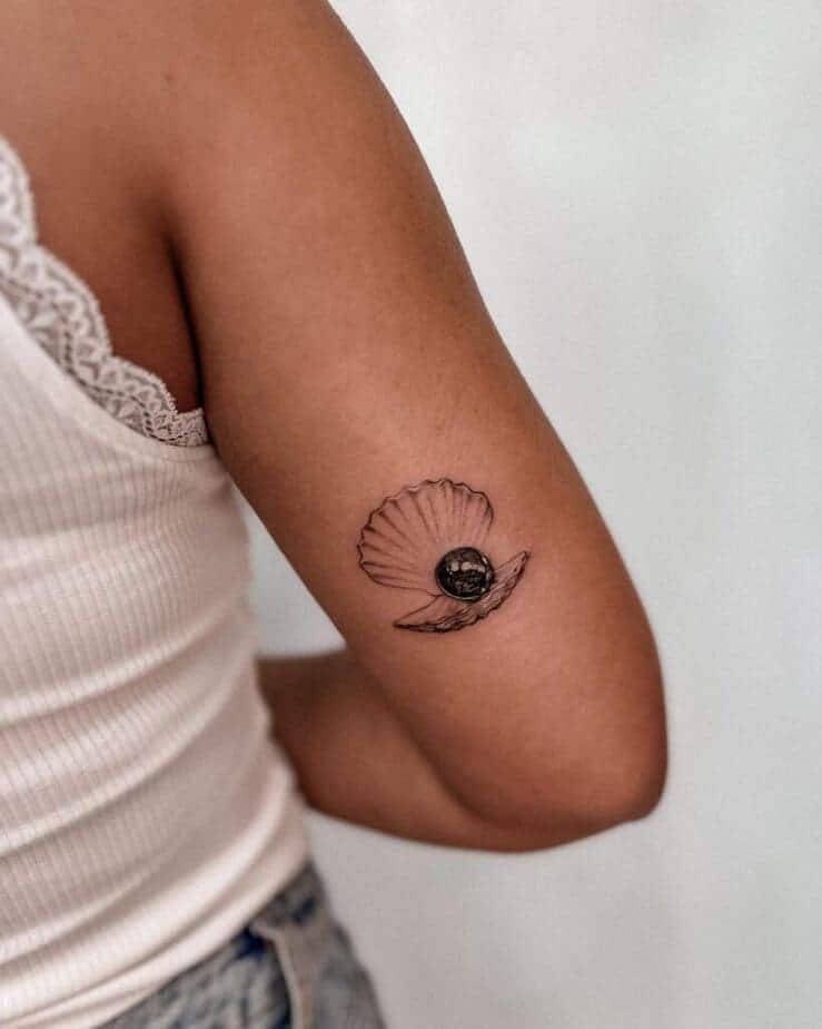 3. Ein schwarzes Muschel-Perlen-Tattoo auf der Rückseite des Arms